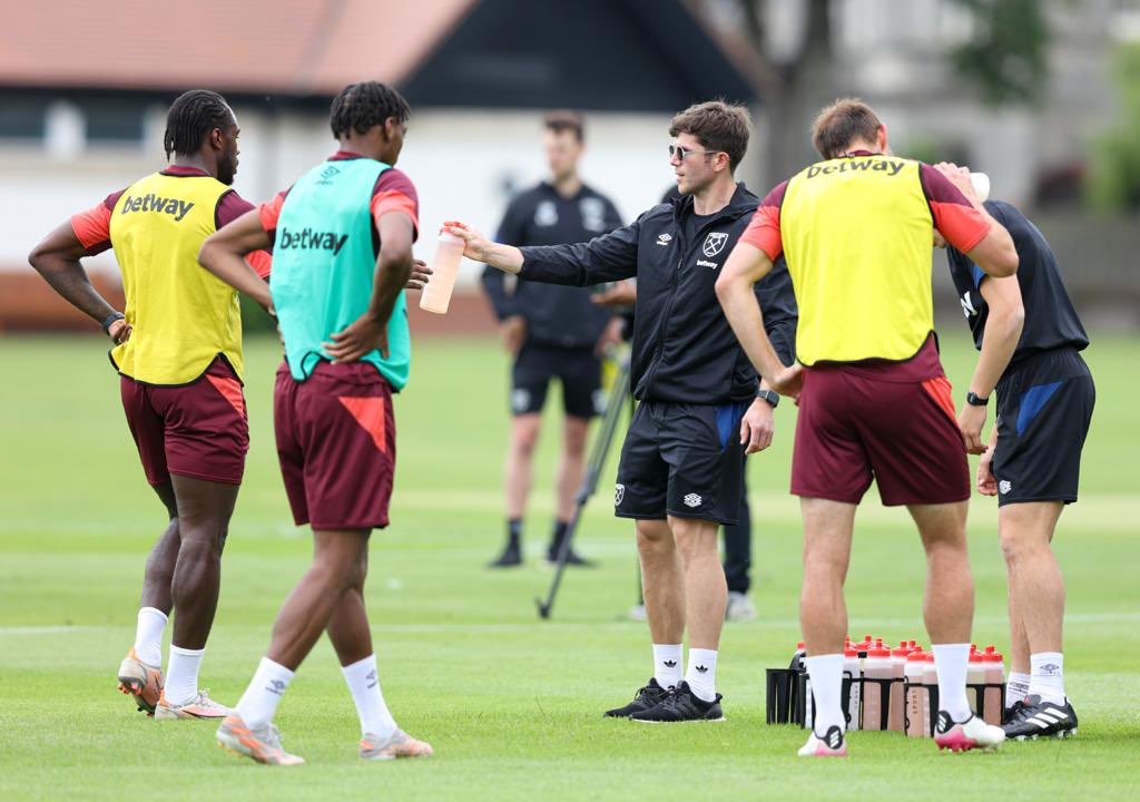 Matt Jones handing a bottle to players during training