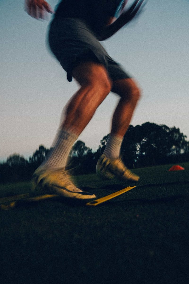 Player sprinting through an agility ladder at dusk